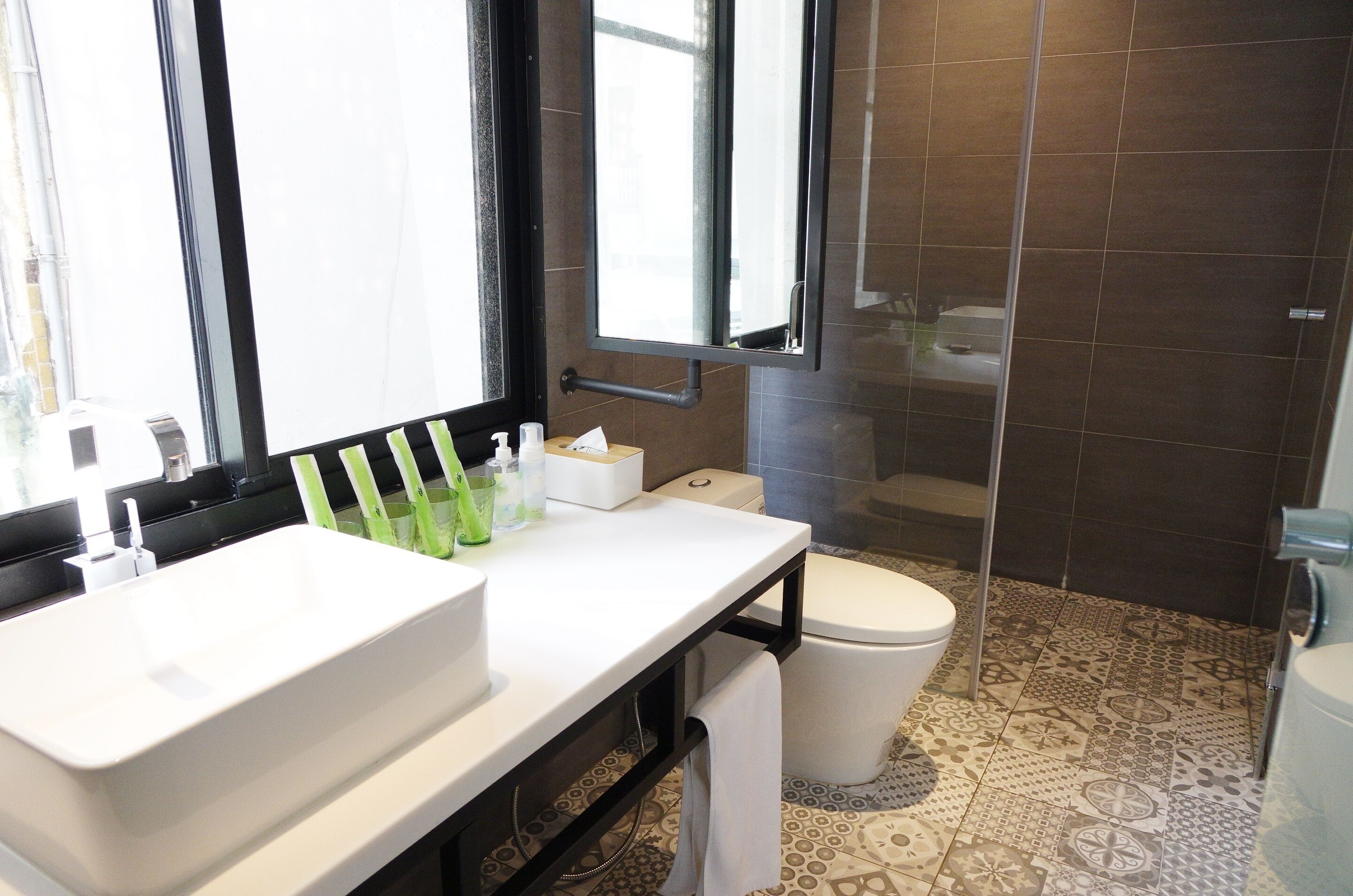 A modern bathroom with a white sink, a mirror, and a toilet.