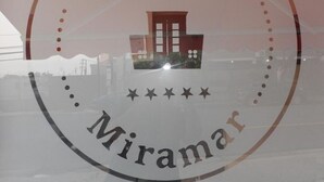 A glass window with the text "Dreams Hotel" and "Miramar" visible, along with a reflection of a building. - Dreams Miramar (San Juan)