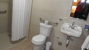 A bathroom with a toilet, sink, and handrail. - Dreams Miramar (San Juan)