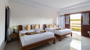 Habitación de hotel con dos camas de madera, ropa de cama blanca y un ventanal con cortinas.