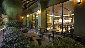 An indoor dining area with tables and chairs, large windows, and interior lighting. - Chillax Heritage (Bangkok)