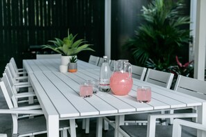 A white table with chairs, a pitcher, and glasses of pink drink. - Redhill Cairns Shared Living – Pembroke St (Parramatta Park)