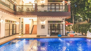 Un immeuble de deux étages doté d’une piscine, de balcons et d’un espace extérieur aménagé pour s’asseoir.