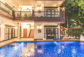 Una piscina al aire libre, sillones reclinables de piscina