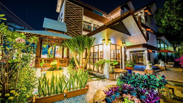 Un hôtel moderne doté d’une cour intérieure agrémentée de plantes en pot et d’un espace salon extérieur.