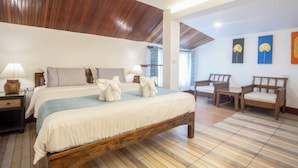 Une chambre à coucher avec un lit en bois, des tables de chevet, une chaise et des œuvres d’art accrochées au mur.