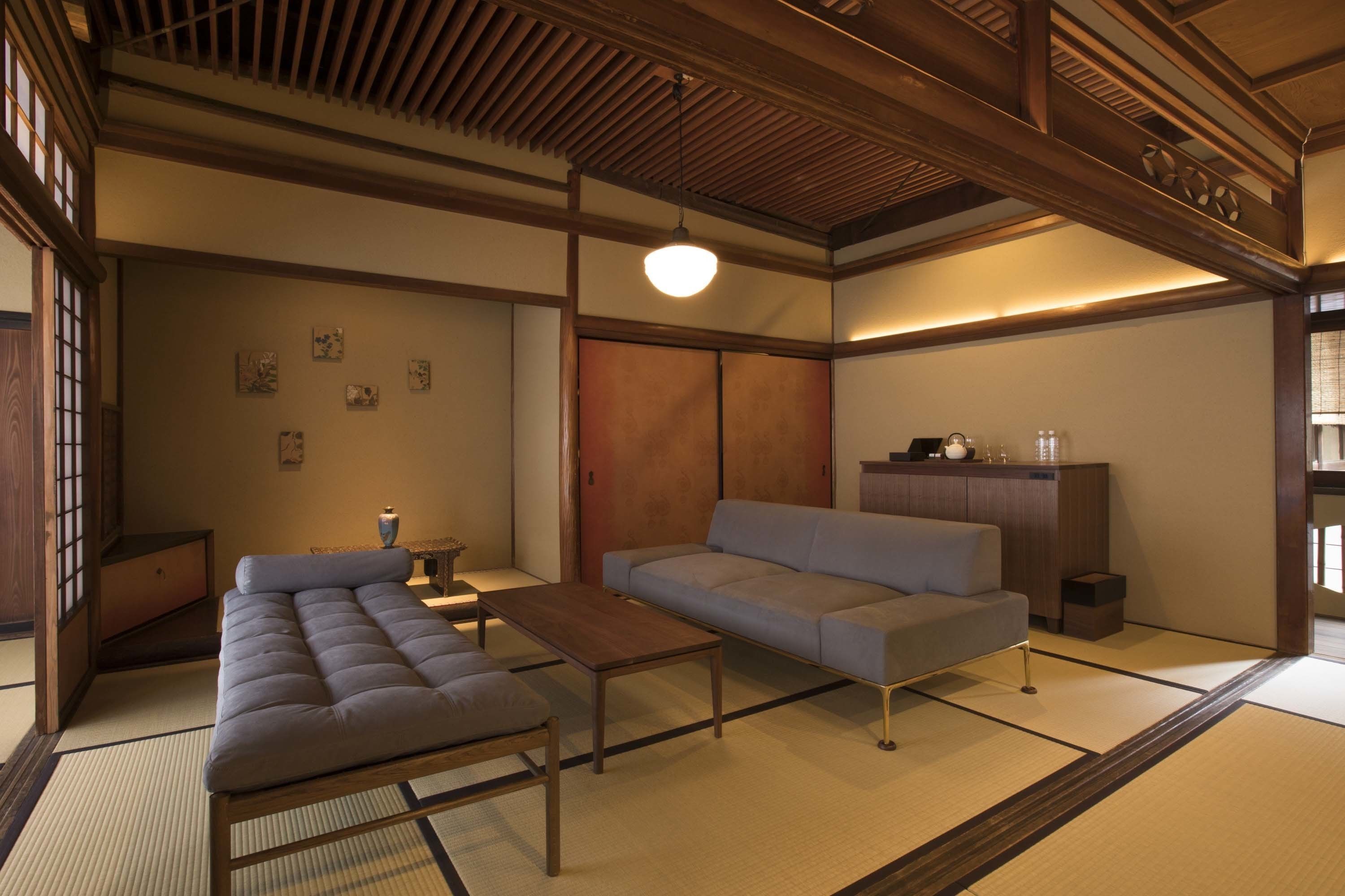Um quarto japonês tradicional com tatames, teto de madeira baixo e uma porta deslizante.