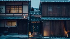 Un edificio japonés tradicional con una puerta de madera, un farol y un letrero con caracteres japoneses.