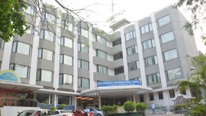 A multi-story hotel with a prominent sign reading "Ashraya International Hotel". - Ashraya International Hotel (Bengaluru)