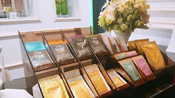 A display of skincare products in a store with a vase of flowers in the background.