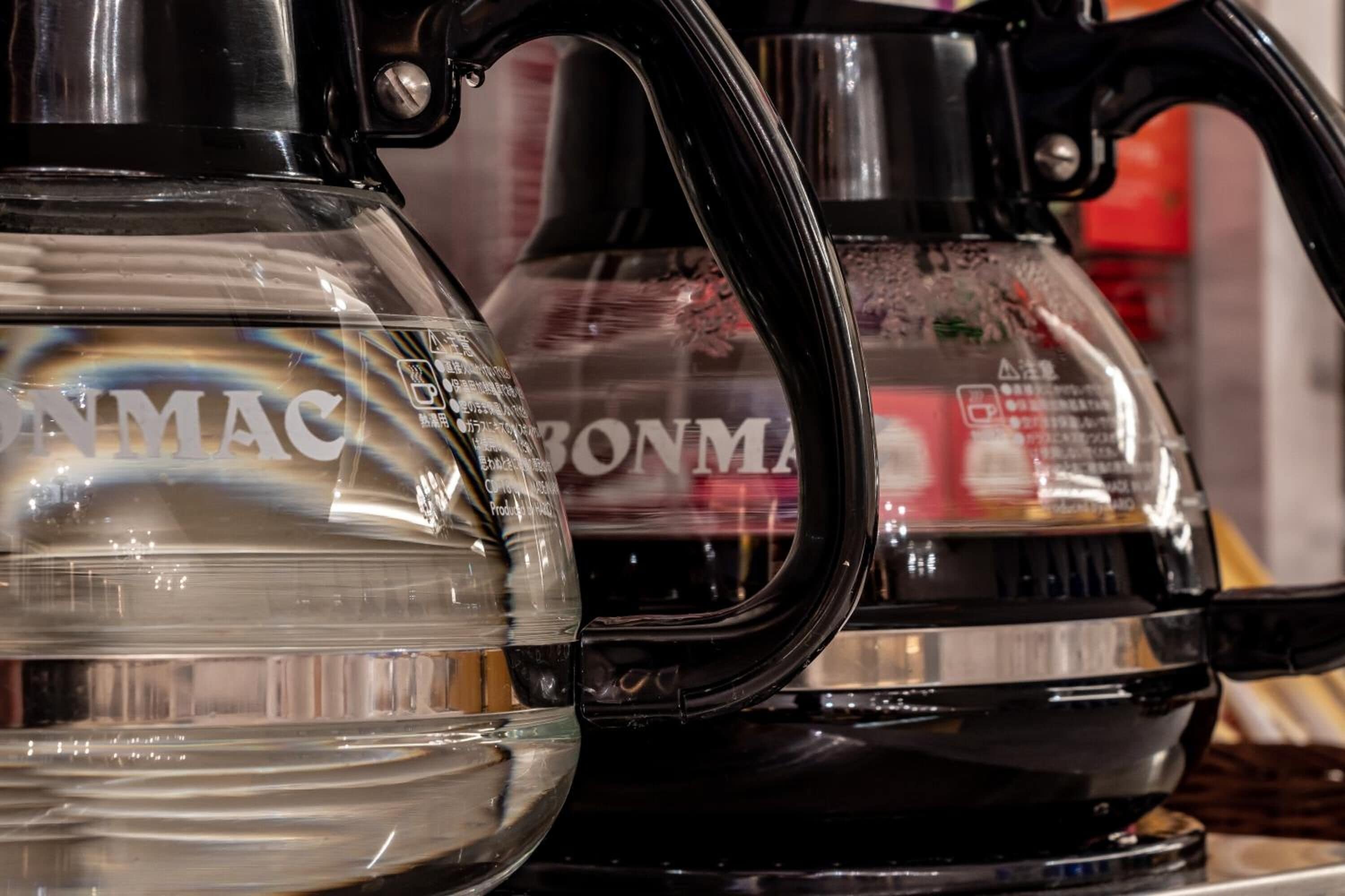 Two kettles, one clear and one black, with visible text and logos.