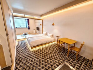 A modern bedroom with a large bed, a small table, and a chair. There is a window with curtains and a view of the outside. - Hotel Imagine Kyoto (Kyoto)