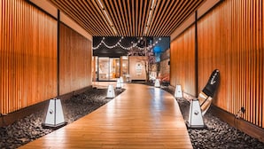 Un pasillo con paneles de madera, suelo de madera y vistas a una habitación con un letrero que dice "HOTEL MAGNE KYOTO".