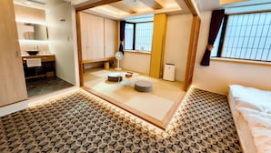 Una habitación de hotel con un espejo grande, una cama, una mesita y un sofá.