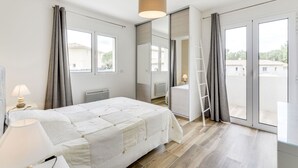 A modern bedroom with a large bed, a desk, a chair, a ladder, and a view of the outside through a sliding glass door. - Beautiful private villa for 8 guests with A/C, WIFI, private pool, TV and terrace (Cogolin)