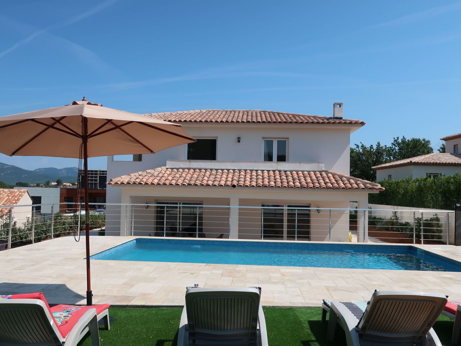 Una casa de dues plantes amb piscina, mobiliari exterior i vistes a les muntanyes.