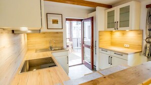 Une cuisine moderne avec des plans de travail en bois, un évier en acier inoxydable et des armoires blanches.
