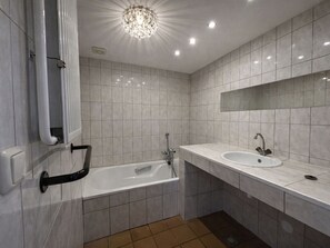 Un baño moderno con bañera, lavamanos y ducha.