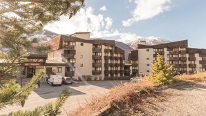 Un hôtel à plusieurs étages doté de balcons, d’un parking et situé dans un cadre montagneux.