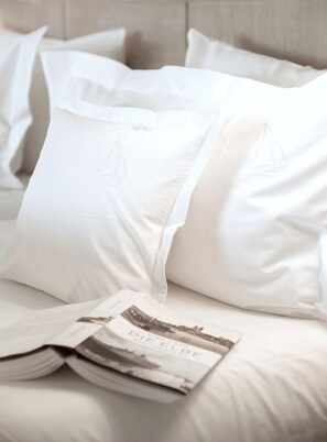 A neatly made bed with white bedding and pillows, and a magazine on the bed. - Hotel Fährhaus Sylt (Sylt)