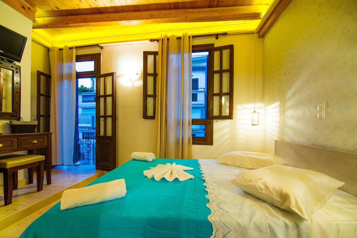 Ein Hotelzimmer mit einem Bett, einem Schreibtisch und einem Vorhangfenster.