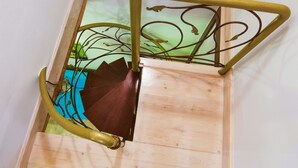 Eine Holztreppe mit Metallgeländer und einer grünen Wand im Hintergrund.