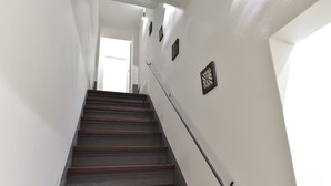A staircase with wooden steps and a handrail, leading to a door at the top.