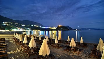 Una playa cerca, sillas reclinables de playa, sombrillas