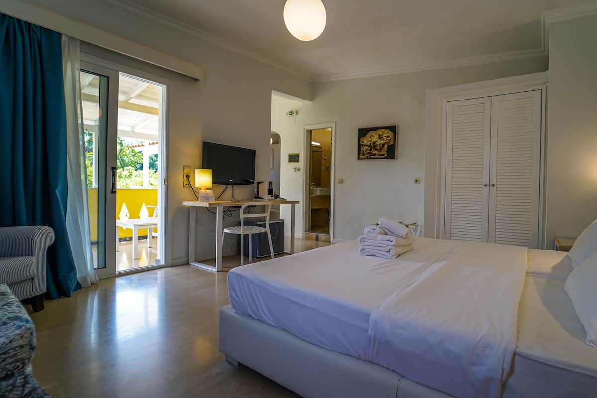 Une chambre d’hôtel comprenant un lit, un bureau avec un ordinateur, une chaise et un téléviseur.