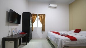 Habitación de hotel con cama, televisor, escritorio y armario.