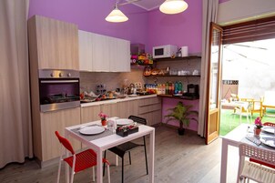 Cozinha compacta com armários de madeira, uma mesa de jantar com cadeiras e um pequeno espaço de refeições com vista.