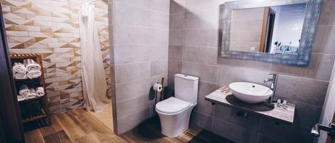 Un baño moderno con ducha, inodoro y lavamanos.