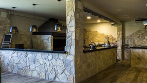 Una cocina con paredes de piedra, suelo de madera e iluminación colgante.