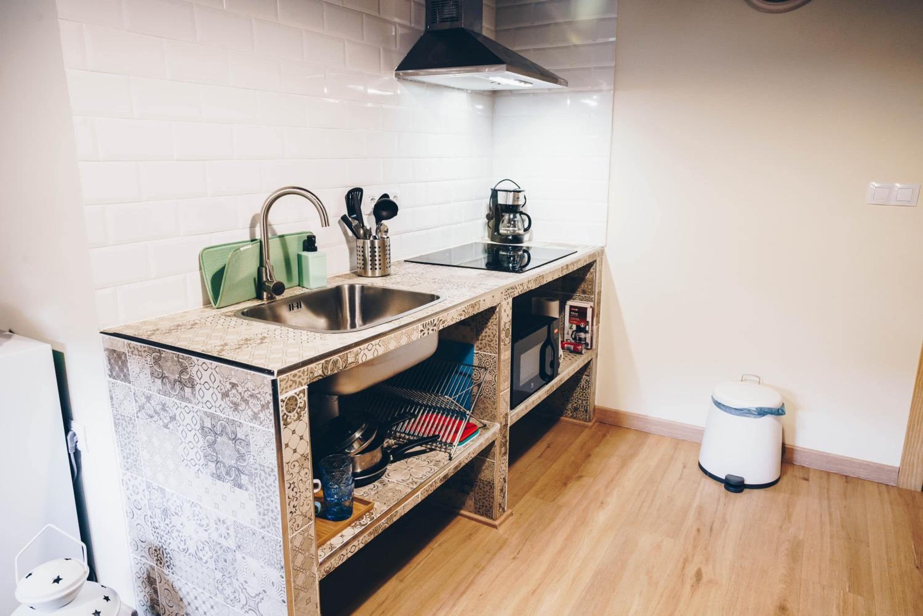 Cocina pequeña con pileta, estufa y microondas.