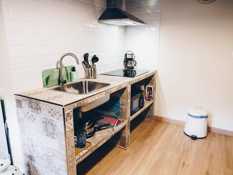 A compact kitchen with a sink, stove, and microwave.