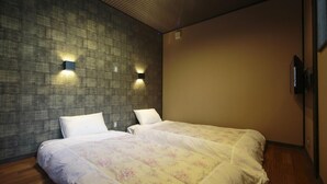 A hotel room with two beds, a textured wall, and two wall-mounted lights. - Kyoyumean (Kyoto)