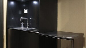 A modern kitchen with a black countertop, a sink, and a built-in oven. - Kyoyumean (Kyoto)