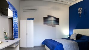 A bedroom with a bed, a desk, a wardrobe, and a ceiling fan. - Migair (Misiliscemi)