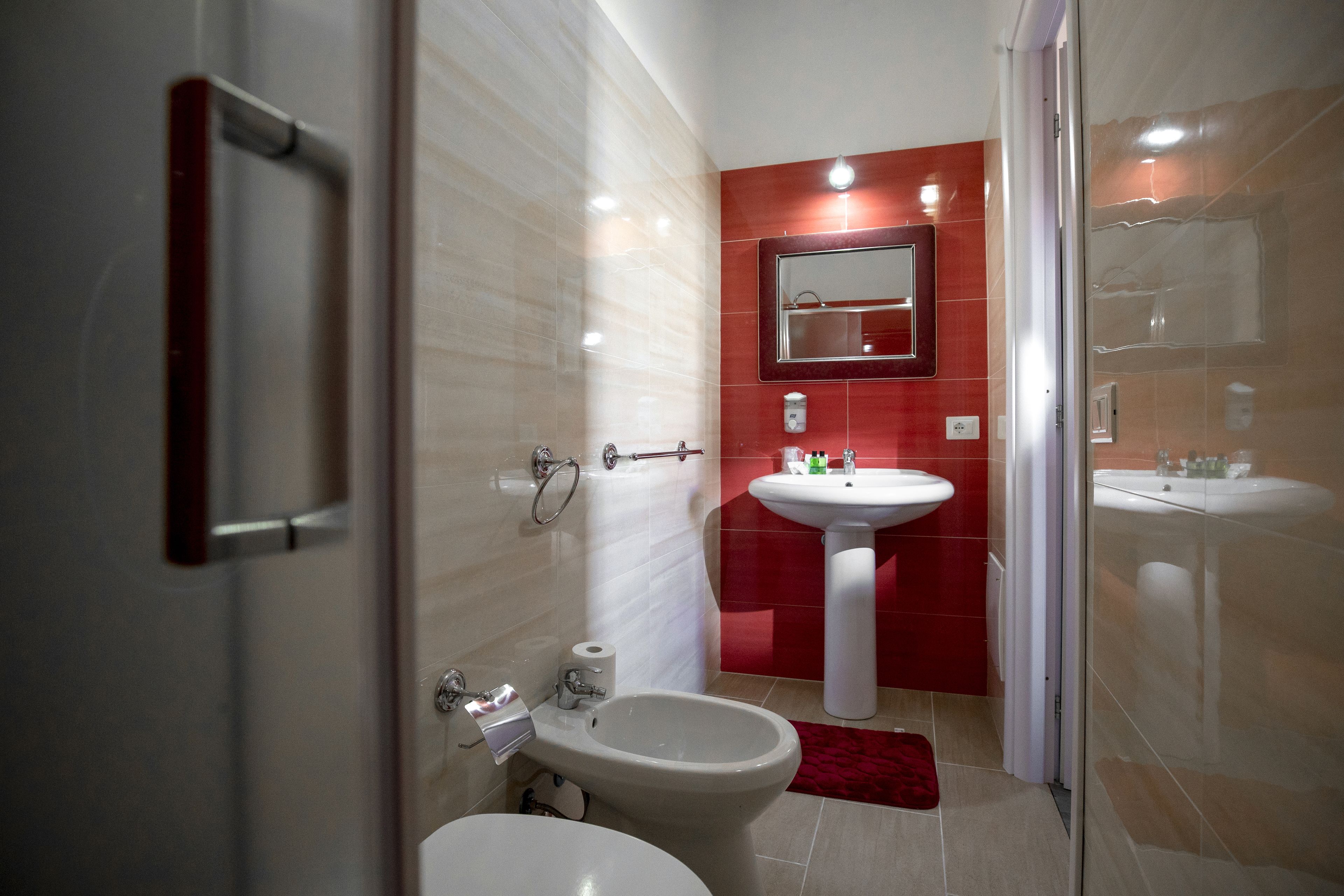 A modern bathroom with a bidet, a sink, and a mirror.