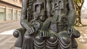 Une sculpture représentant deux personnages assis sur un banc.