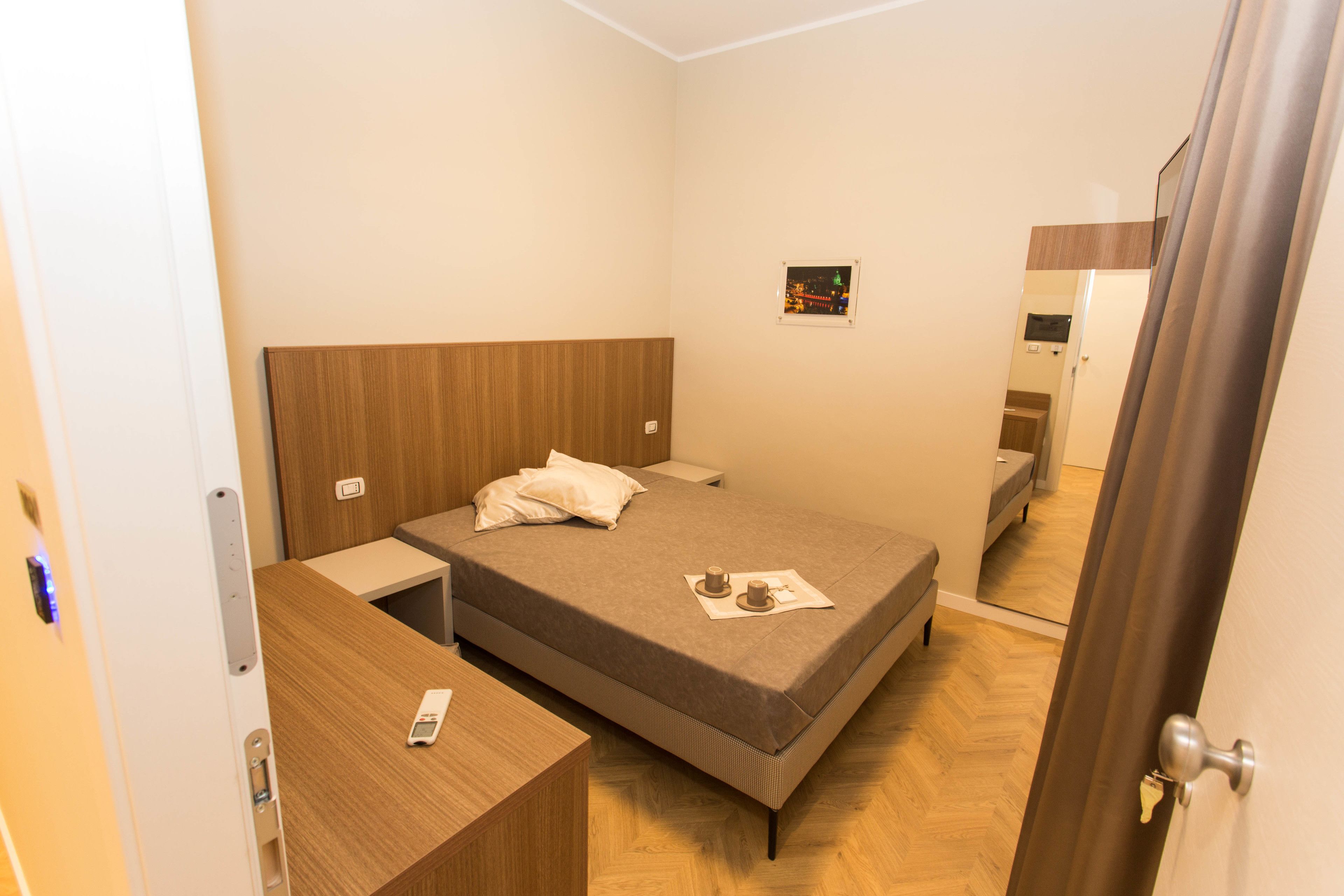 Une chambre à coucher avec un lit, une table de chevet et un miroir.