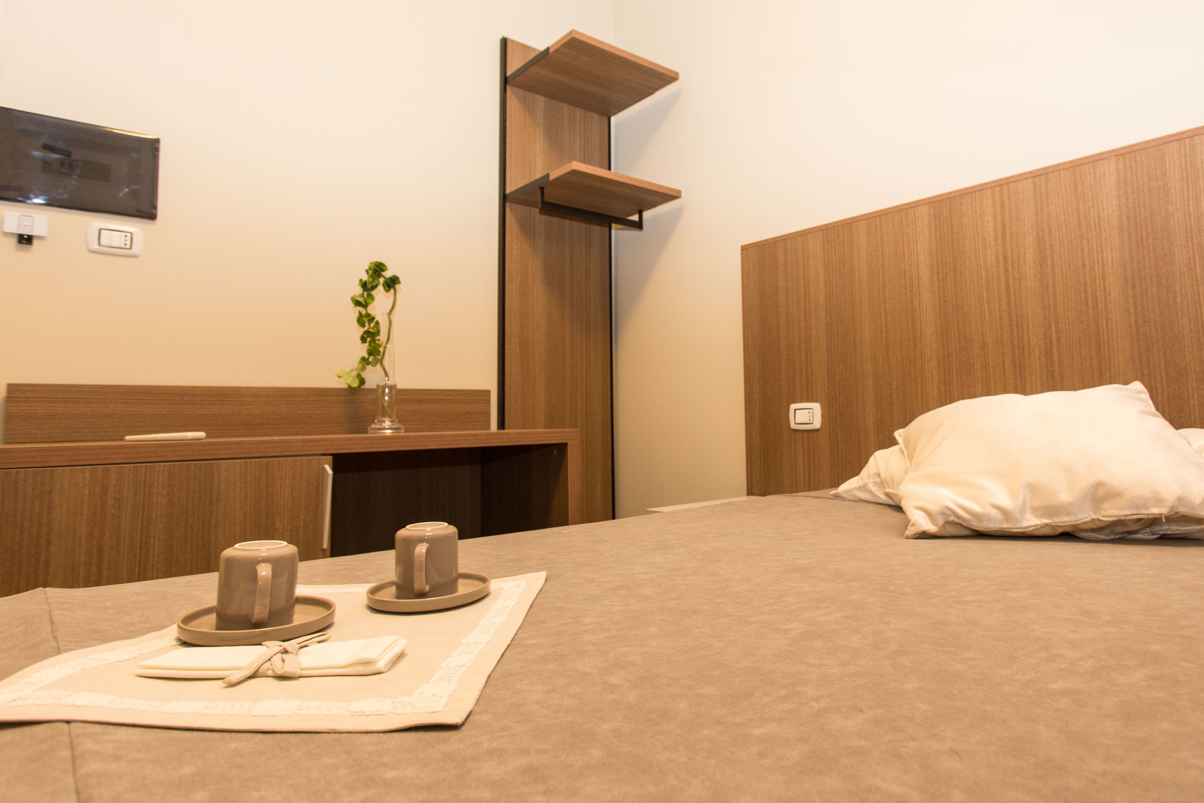 Une chambre d’hôtel avec un lit, une table de chevet et un miroir.