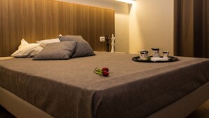 A neatly made bed with a brown bedspread, pillows, and a tray with teapots and a rose. - Le Affacciate Bruzie Home (Cosenza)