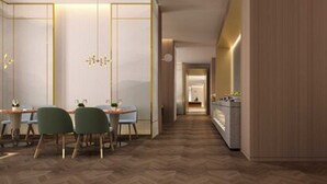 A modern dining area with a herringbone wood floor, a round table, and green chairs. - Sincere Residence Changfeng (Shanghai)