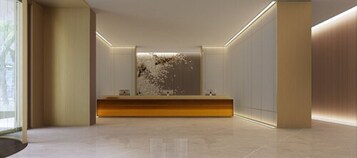 Un área de recepción moderna con mostrador, un muro decorativo y un piso de baldosas limpias.