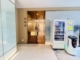 A reception area with a counter, a vending machine, and a wall with a sign.