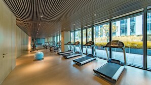 Uma academia moderna com esteiras, bolas de exercício e equipamentos de cardio.