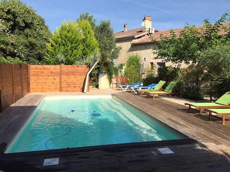 Una piscina al aire libre de temporada, sillones reclinables de piscina