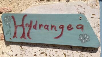 A wooden sign with the word "Hydrangea" and floral designs.