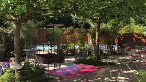 Un patio exterior con piscina, rodeado de árboles y plantas.